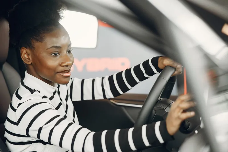 Smiling driver behind the wheel of her car